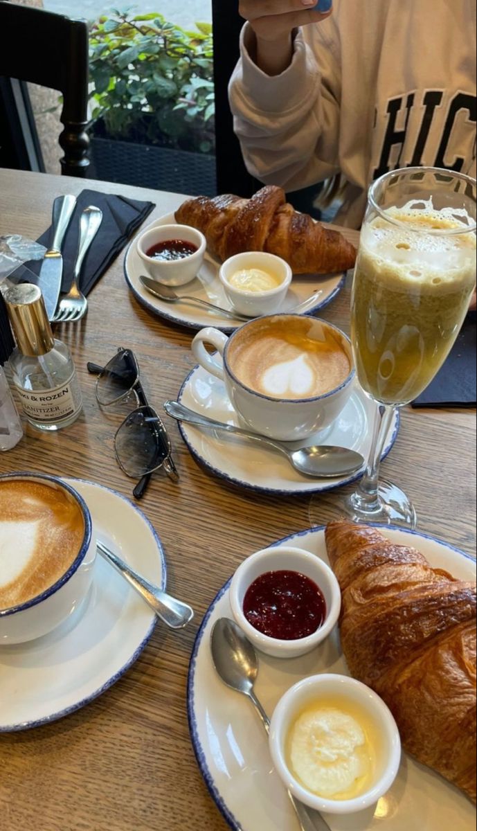Desayuno con croissant, café con leche y jugo verde